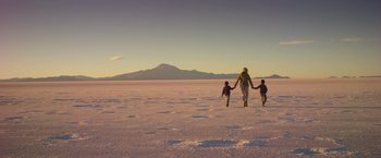 Movie still from “Salt and Fire” (2016), directed by Werner Herzog – A woman and two children walking across a snow covered field; Wide shot, Low angle