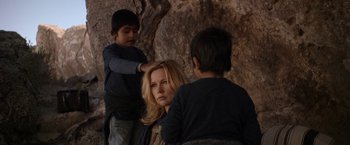 Movie still from “Salt and Fire” (2016), directed by Werner Herzog – A woman with two young boys standing next to a rock wall; Medium shot, Over the shoulder angle