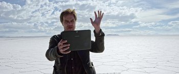 Movie still from “Salt and Fire” (2016), directed by Werner Herzog – A man holding a tablet in his hands; Medium shot, Low angle