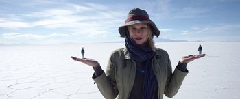 Movie still from “Salt and Fire” (2016), directed by Werner Herzog – A woman holding out her hand while standing in the middle of a desert; Medium shot, Low angle