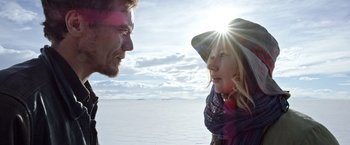Movie still from “Salt and Fire” (2016), directed by Werner Herzog – A man and a woman facing each other in front of a body of water; Close Up shot, Low angle