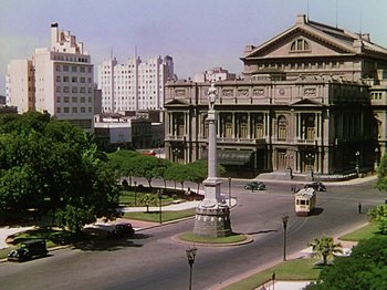 Movie still from “Saludos Amigos” (1942), directed by Jack Kinney – An intersection in a city with a statue in the middle of the street; Extreme Wide shot, High angle
