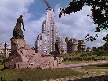 Movie still from “Saludos Amigos” (1942), directed by Jack Kinney – A statue of a man and a woman on top of a hill; Extreme Wide shot, Low angle