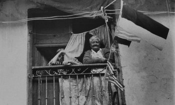 Movie still from “Salut les Cubains” (1963), directed by Agnès Varda – An old man standing on a balcony looking out of the window; Wide shot, Low angle