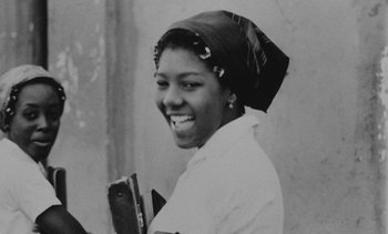 Movie still from “Salut les Cubains” (1963), directed by Agnès Varda – An old black and white photo of a woman smiling; Close Up shot, Low angle