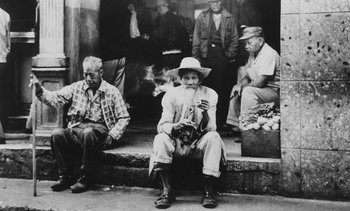 Movie still from “Salut les Cubains” (1963), directed by Agnès Varda – An old man sitting on the steps smoking a pipe; Wide shot, High angle