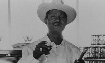 Movie still from “Salut les Cubains” (1963), directed by Agnès Varda – A man wearing a white cowboy hat holding a glass of wine; Close Up shot, Low angle