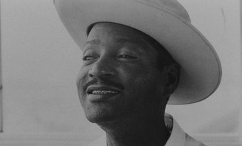 Movie still from “Salut les Cubains” (1963), directed by Agnès Varda – A black and white photo of a man wearing a cowboy hat; Close Up shot, Low angle