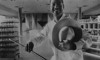 Movie still from “Salut les Cubains” (1963), directed by Agnès Varda – A man holding a hat while holding a cane; Close Up shot, Low angle