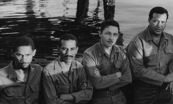 Movie still from “Salut les Cubains” (1963), directed by Agnès Varda – Black and white photograph of men in military uniforms in water; Medium shot, High angle