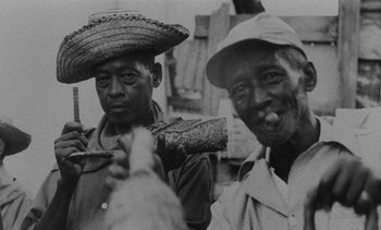 Movie still from “Salut les Cubains” (1963), directed by Agnès Varda – A black - and - white photo of two men smoking; Close Up shot, High angle