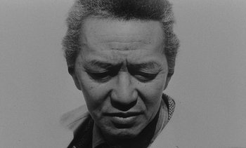 Movie still from “Salut les Cubains” (1963), directed by Agnès Varda – An old black and white photo of a man's face; Close Up shot, Low angle