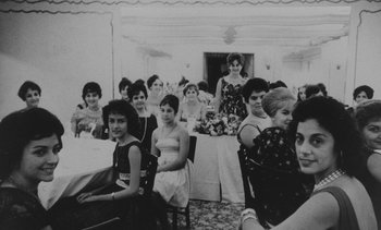 Movie still from “Salut les Cubains” (1963), directed by Agnès Varda – Black and white photograph of a group of women sitting at a table; Medium shot, High angle