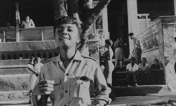 Movie still from “Salut les Cubains” (1963), directed by Agnès Varda – A young man holding a cup in a black and white photo; Medium shot, Low angle