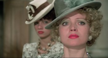 Movie still from “Salò, or the 120 Days of Sodom” (1975), directed by Pier Paolo Pasolini – Two women wearing hats and looking at the camera; Close Up shot, Low angle