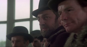 Movie still from “Salò, or the 120 Days of Sodom” (1975), directed by Pier Paolo Pasolini – A group of men wearing hats and a beard; Close Up shot, Low angle