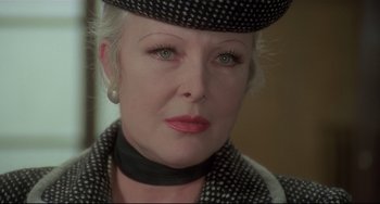 Movie still from “Salò, or the 120 Days of Sodom” (1975), directed by Pier Paolo Pasolini – An older woman wearing a black and white hat; Close Up shot, Over the shoulder angle