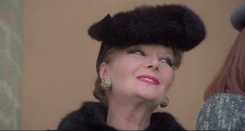 Movie still from “Salò, or the 120 Days of Sodom” (1975), directed by Pier Paolo Pasolini – An older woman wearing a black hat and a fur coat; Close Up shot, Low angle