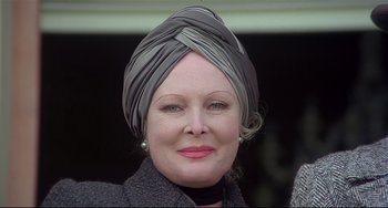 Movie still from “Salò, or the 120 Days of Sodom” (1975), directed by Pier Paolo Pasolini – An older woman wearing a turban and a black coat; Close Up shot, Low angle