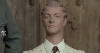 Movie still from “Salò, or the 120 Days of Sodom” (1975), directed by Pier Paolo Pasolini – A mannequin wearing a suit and tie; Close Up shot, High angle