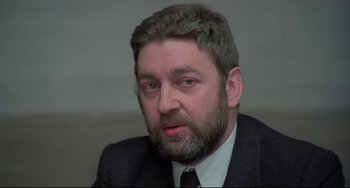 Movie still from “Salò, or the 120 Days of Sodom” (1975), directed by Pier Paolo Pasolini – A person wearing a suit and tie; Close Up shot, Over the shoulder angle