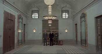 Movie still from “Salò, or the 120 Days of Sodom” (1975), directed by Pier Paolo Pasolini – A group of men standing next to each other in a room; Wide shot, Low angle
