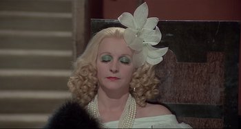 Movie still from “Salò, or the 120 Days of Sodom” (1975), directed by Pier Paolo Pasolini – A woman wearing a white dress with a flower in her hair; Close Up shot, High angle