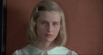Movie still from “Salò, or the 120 Days of Sodom” (1975), directed by Pier Paolo Pasolini – A young girl with a white dress and a hair clip; Close Up shot, Low angle