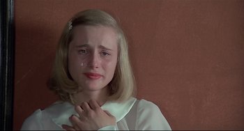 Movie still from “Salò, or the 120 Days of Sodom” (1975), directed by Pier Paolo Pasolini – A young girl is crying with her hand on her chest; Close Up shot, High angle