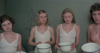 Movie still from “Salò, or the 120 Days of Sodom” (1975), directed by Pier Paolo Pasolini – Two young women holding bowls in a room; Medium shot, Low angle