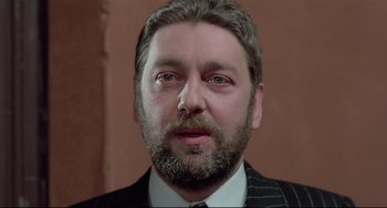 Movie still from “Salò, or the 120 Days of Sodom” (1975), directed by Pier Paolo Pasolini – A person wearing a suit and tie; Close Up shot, Low angle