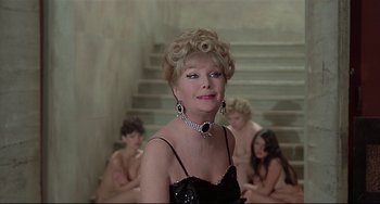 Movie still from “Salò, or the 120 Days of Sodom” (1975), directed by Pier Paolo Pasolini – A woman in a black dress and some naked women; Medium shot, Over the shoulder angle