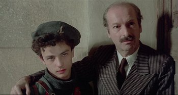 Movie still from “Salò, or the 120 Days of Sodom” (1975), directed by Pier Paolo Pasolini – A man and a young boy posing for a picture; Close Up shot, Low angle