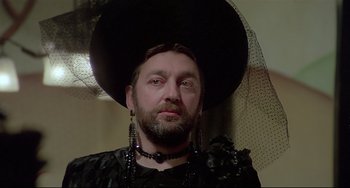 Movie still from “Salò, or the 120 Days of Sodom” (1975), directed by Pier Paolo Pasolini – A man with a beard wearing a black hat; Close Up shot, Low angle