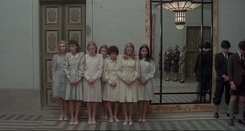 Movie still from “Salò, or the 120 Days of Sodom” (1975), directed by Pier Paolo Pasolini – A group of young girls standing in front of a building; Wide shot, Low angle