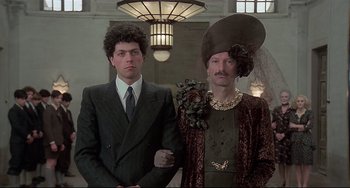 Movie still from “Salò, or the 120 Days of Sodom” (1975), directed by Pier Paolo Pasolini – Two men in suits and hats standing next to each other in a room; Medium shot, Low angle