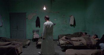 Movie still from “Salò, or the 120 Days of Sodom” (1975), directed by Pier Paolo Pasolini – A person in a room with a green wall; Wide shot, High angle
