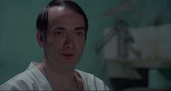 Movie still from “Salò, or the 120 Days of Sodom” (1975), directed by Pier Paolo Pasolini – A person wearing a white shirt; Close Up shot, High angle