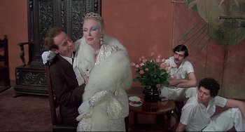 Movie still from “Salò, or the 120 Days of Sodom” (1975), directed by Pier Paolo Pasolini – A man and a woman dressed up in a living room; Medium shot, Over the shoulder angle