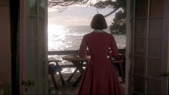 Movie still from “Same Time, Next Year” (1978), directed by Robert Mulligan – A woman in a red dress looking out at the ocean; Wide shot, Over the shoulder angle