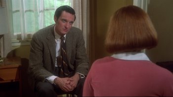Movie still from “Same Time, Next Year” (1978), directed by Robert Mulligan – A man sitting in front of a woman in front of a window; Medium shot, Over the shoulder angle