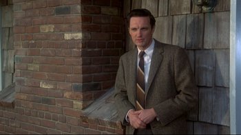 Movie still from “Same Time, Next Year” (1978), directed by Robert Mulligan – A man in a suit and tie standing in front of a brick wall; Close Up shot, Low angle