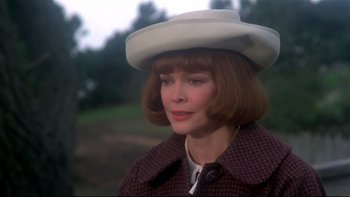 Movie still from “Same Time, Next Year” (1978), directed by Robert Mulligan – A person wearing a hat with trees in the background; Close Up shot, Over the shoulder angle