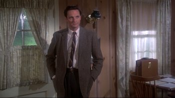 Movie still from “Same Time, Next Year” (1978), directed by Robert Mulligan – A man in a suit and tie standing in front of a mirror; Medium shot, Over the shoulder angle
