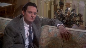 Movie still from “Same Time, Next Year” (1978), directed by Robert Mulligan – A man sitting on a chair in a suit and tie; Close Up shot, High angle