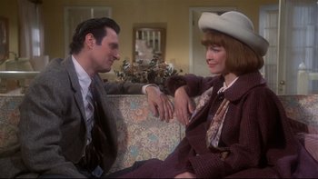 Movie still from “Same Time, Next Year” (1978), directed by Robert Mulligan – A man and a woman sitting next to each other on a couch; Medium shot, High angle