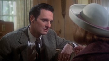 Movie still from “Same Time, Next Year” (1978), directed by Robert Mulligan – A man wearing a suit and tie sitting next to a woman; Close Up shot, Over the shoulder angle