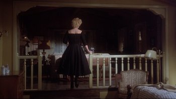 Movie still from “Same Time, Next Year” (1978), directed by Robert Mulligan – A woman in a black dress standing in a room; Wide shot, Low angle