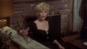 Movie still from “Same Time, Next Year” (1978), directed by Robert Mulligan – A woman sitting at a table holding a glass of wine; Medium shot, High angle