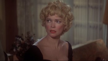 Movie still from “Same Time, Next Year” (1978), directed by Robert Mulligan – A woman in a black dress with blonde curly hair; Close Up shot, Over the shoulder angle